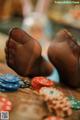 A woman's feet in black stockings on a table with poker chips.