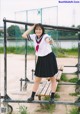 A woman in a school uniform posing for a picture.