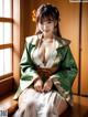 A woman in a green and white kimono sitting on a window sill.