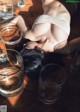 A woman laying on a wooden floor next to glasses of water.