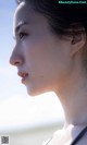 A close up of a woman's face on the beach.